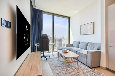 a living room with a couch and a table at STAY BY LATINEM Luxury 1BR Holiday Home W 3516 Near Burj Khalifa in Dubai