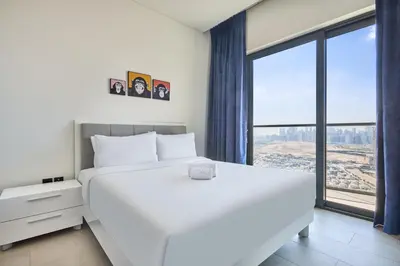 a white bed in a room with a large window at STAY BY LATINEM Luxury 1BR Holiday Home W 3516 Near Burj Khalifa in Dubai