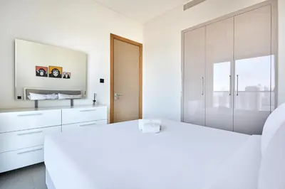 a white bathroom with white cabinets and a mirror at STAY BY LATINEM Luxury 1BR Holiday Home W 3516 Near Burj Khalifa in Dubai