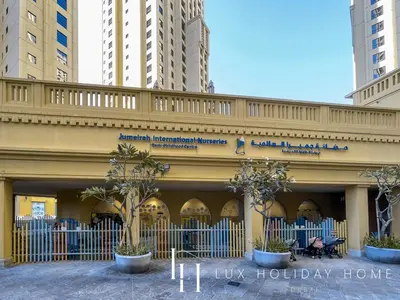 a building with palm trees in front of it at LUX The Dubai Eye View JBR Studio in Dubai