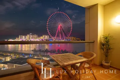 a view of a ferris wheel at night from a balcony at LUX The Dubai Eye View JBR Studio in Dubai
