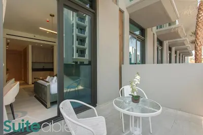 a patio with a table and chairs and a bedroom at Urban Retreat Studio in The Autograph JVC in Dubai