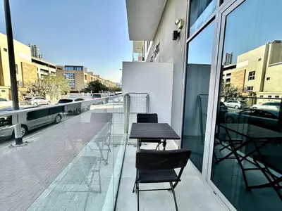 a balcony with two chairs and a table on a building at Homes2Retreat - Stylish Studio Gym & Pool, JVC Dubai in Dubai