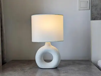 a vase shaped lamp with a white lamp shade at Stylish Fully Furnished 1BH Apartment Close by Dubai Science Park, Dubai Miracle Garden and Butterfly Garden in Dubai