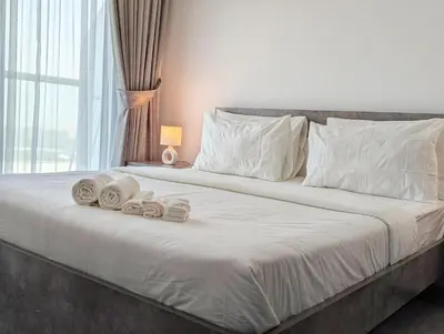 a bedroom with a bed with towels on it at Stylish Fully Furnished 1BH Apartment Close by Dubai Science Park, Dubai Miracle Garden and Butterfly Garden in Dubai