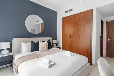 a bedroom with a large bed with a mirror on the wall at Silkhaus Residences Towers 3BR Near Burj Khalifa in Dubai