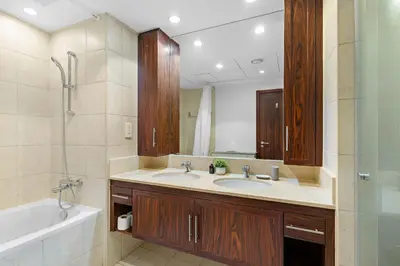 a bathroom with two sinks and a tub and a mirror at Silkhaus Residences Towers 3BR Near Burj Khalifa in Dubai