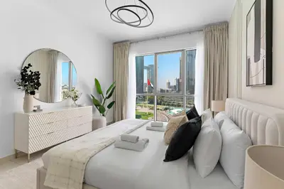 a bedroom with a large bed with a large window at Silkhaus Residences Towers 3BR Near Burj Khalifa in Dubai