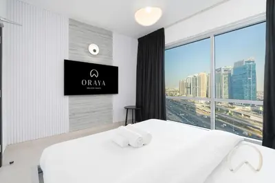 a bedroom with two white beds and a flat screen tv at Upgraded 2BR In La Riviera Marina - Close to Beach in Dubai