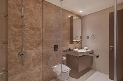 a bathroom with a shower with a toilet and a sink at Beach View 1BR at Beachfront 50 Off Eid Offer in Dubai