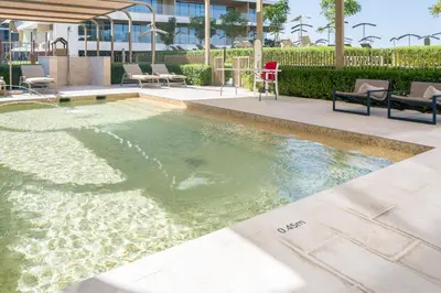 a swimming pool in the middle of a building at Beach View 1BR at Beachfront 50 Off Eid Offer in Dubai