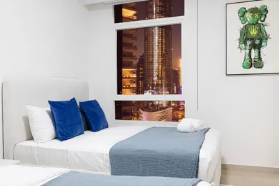 a bedroom with a bed with blue pillows and a window at Prime Location - 2BR with Spectacular Sea View in Dubai