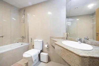 a bathroom with a sink and a toilet and a tub at Prime Location - 2BR with Spectacular Sea View in Dubai