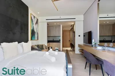 a hotel room with a large bed and a desk at Studio in The Autograph JVC w amazing facilities in Dubai