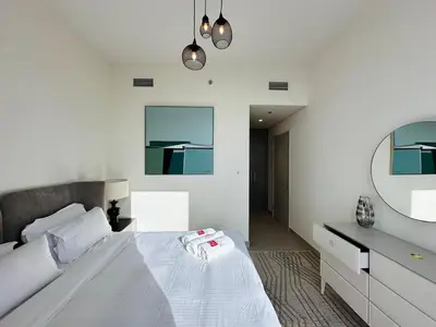 a bedroom with a white bed and a mirror at Your Home away from Home in Dubai