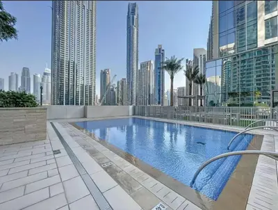 a large swimming pool in a city with tall buildings at Your Home away from Home in Dubai