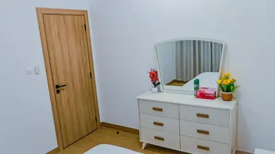 a bedroom with a dresser with a mirror on it at Luxurious holiday homes in Dubai