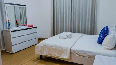 a bedroom with a bed and a dresser and a mirror at Luxurious holiday homes in Dubai