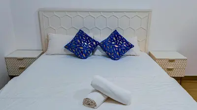 a bed with blue pillows and a towel on it at Luxurious holiday homes in Dubai