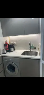 a kitchen with a sink and a washing machine at Azizi riviera in Dubai