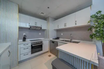 a kitchen with white cabinets and a sink at Stunning Views Spacious 3BR Dubai Marina in Dubai