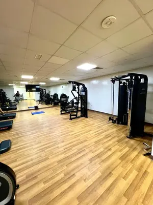 a gym with several tread machines and a wooden floor at Vibrant studio - 15m to marina in Dubai