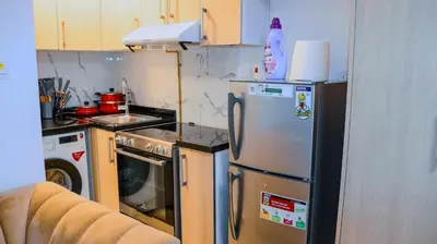 a small kitchen with a refrigerator and a stove at Luxurious Studio Apartment in Dubai