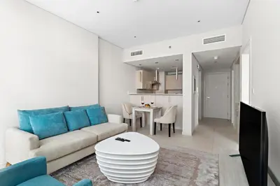 a living room with a couch and a table at 1BR Apartment on The Palm Walk to Beach Mall Pool Restaurants in Dubai