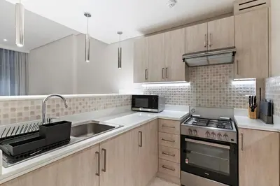 a kitchen with a sink and a stove at 1BR Apartment on The Palm Walk to Beach Mall Pool Restaurants in Dubai