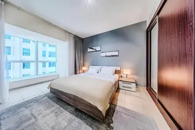 a bedroom with a large bed and a large window at Cozy 1 Bedroom in Elite Residence in Dubai