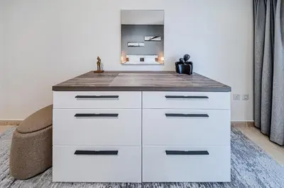 a white dresser in a room with a mirror at Cozy 1 Bedroom in Elite Residence in Dubai