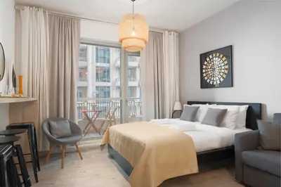 a bedroom with a bed and a chair and a window at Boulevard Central Towers Downtown Dubai - By Home Of Choice in Dubai
