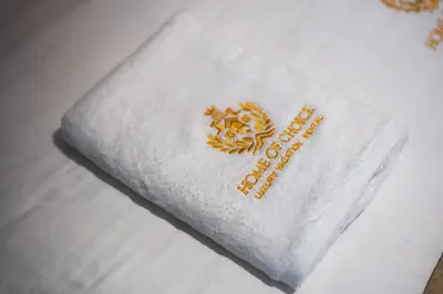 a white towel with a logo on top of a bed at Boulevard Central Towers Downtown Dubai - By Home Of Choice in Dubai