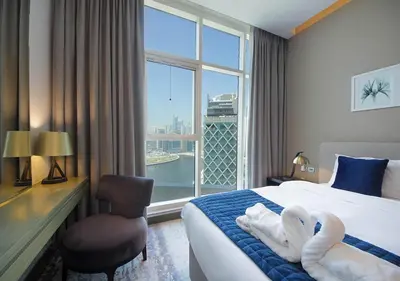 a hotel room with a bed with swans towels on it at Luxury Studio Apartment Canal View Near Dubai Mall in Dubai