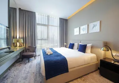 a hotel room with a bed and a television at Luxury Studio Apartment Canal View Near Dubai Mall in Dubai