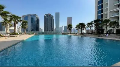 a large swimming pool in a city with tall buildings at Luxury Studio Apartment Canal View Near Dubai Mall in Dubai