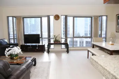 a living room with a couch and a television at Luxury Two Bedroom Apt Facing Burj Khalifa in Dubai