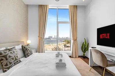 a bedroom with a bed with a view of a beach at Burj Alarab & Atlantis Palm Sea view, Beachfront, peaceful 3 Bedroom Apartment TIARA Residence with Pool, fast Wifi in Dubai