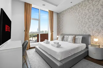 a bedroom with a bed and a desk and a window at Burj Alarab & Atlantis Palm Sea view, Beachfront, peaceful 3 Bedroom Apartment TIARA Residence with Pool, fast Wifi in Dubai