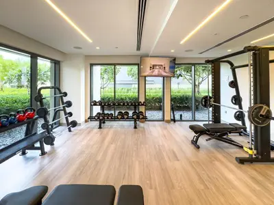 a fitness room with treadmills and weights and windows at Burj Royale 1 BR 5 Min Walk to Burj Khalifa in Dubai