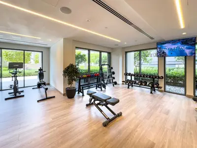 a gym with several exercise equipment in a room with windows at Burj Royale 1 BR 5 Min Walk to Burj Khalifa in Dubai