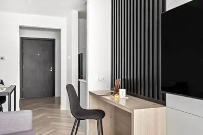 a living room with a television and a desk with a chair at Stylish Dubai Downtown Studio by Burj Khalifa in Dubai