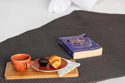 a tray with a book and a cup of coffee and croissants at Stylish Dubai Downtown Studio by Burj Khalifa in Dubai