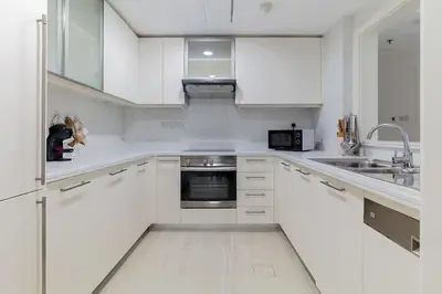 a white kitchen with white cabinets and a sink at Luxury One-Bedroom Burj Khalifa in Dubai