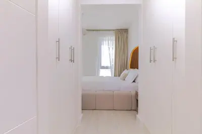 a white bedroom with a bed and a window at Luxury One-Bedroom Burj Khalifa in Dubai
