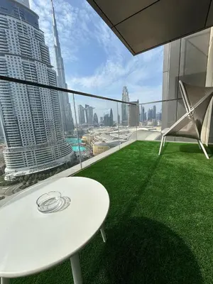 a white table and chairs on the balcony of a building at 2BR Full Burj Khalifa View - Eid Promo 50 Off in Dubai