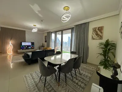 a living room with a glass table and chairs at 2BR Full Burj Khalifa View - Eid Promo 50 Off in Dubai
