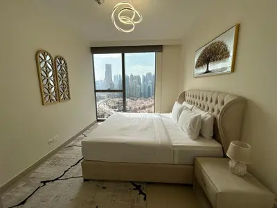 a bedroom with a large bed and a window at 2BR Full Burj Khalifa View - Eid Promo 50 Off in Dubai