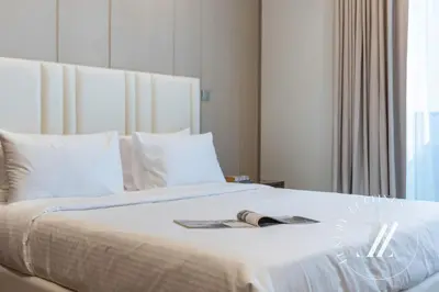 a bed with a book and a magazine on it at 3BDR Business Bay Bliss High Floor Private Balcony in Dubai