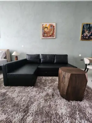 a living room with a black couch and a wooden coffee table at Bright Beachfront Studio with Breathtaking Views in Dubai
